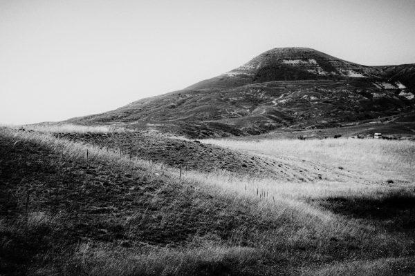 Dramatic black and white image of serene rolling hills and a distant mountain. Nature 4K