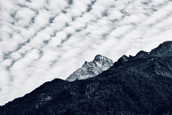 Dramatic mountain peak under a textured cloud-filled sky, showcasing nature's beauty. Nature 4K