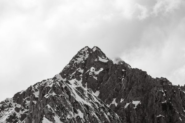 Dramatic snow-covered mountain peak under cloudy skies in Innsbruck, Austria. Nature 4K