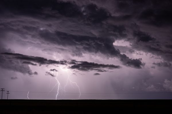 Dramatic stormy sky with intense lightning strikes illuminating dark clouds. Dark 4K