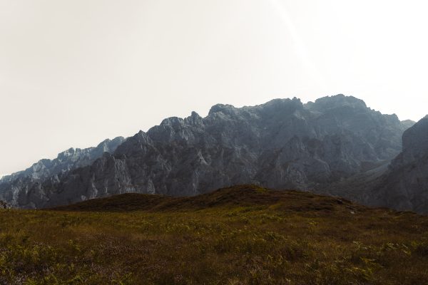 Dramatic view of Spanish mountains under a clear sky, showcasing rocky peaks and lush foreground. Nature 4K