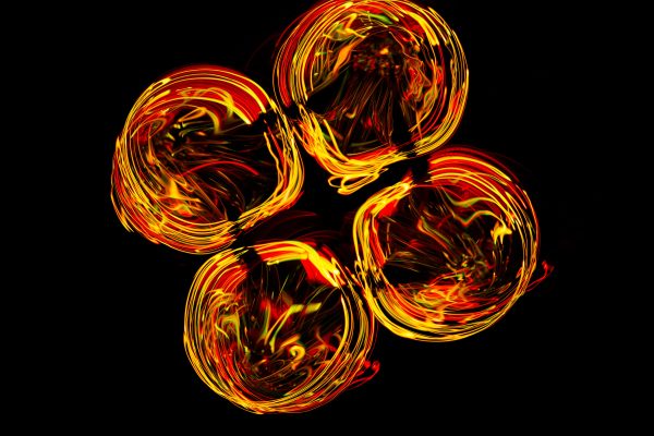 Dynamic light painting circles in warm colors on a black background. Abstrait 4K