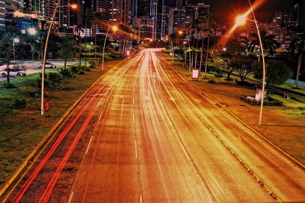 Dynamic long exposure of city street capturing vibrant light trails and urban skyline at night. Voitures 4K