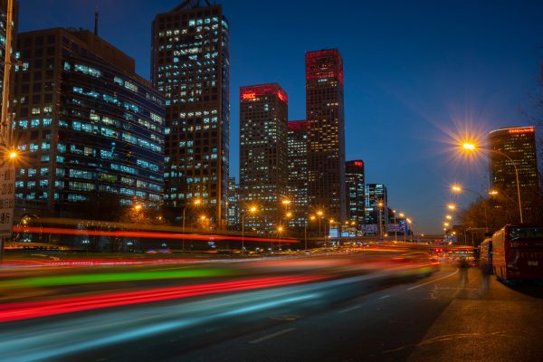 Dynamic night scene with blurred traffic lights against modern skyscrapers in a bustling city. Voitures 4K