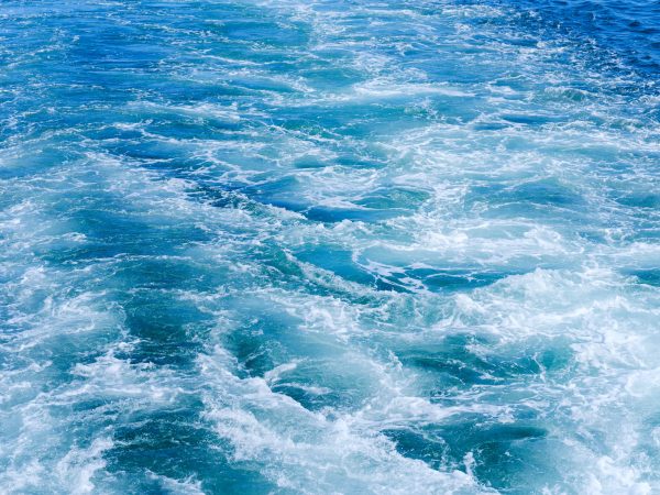 Dynamic ocean waves in a vivid blue setting with ship wake patterns. Nature 4K