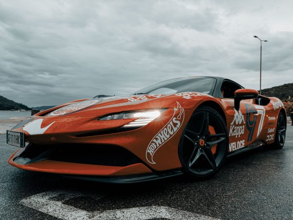Dynamic shot of an electric sports car adorned with decals on a rainy day in Budva, Montenegro. Voitures 4K