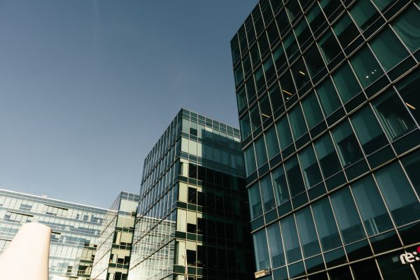 Elegant modern glass office buildings with reflective windows under a clear blue sky, showcasing urban architecture. Architecture 4K