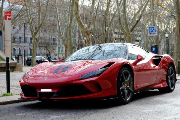 Elegant red sports car elegantly parked on a Lisbon street with a sleek design. Voitures 4K