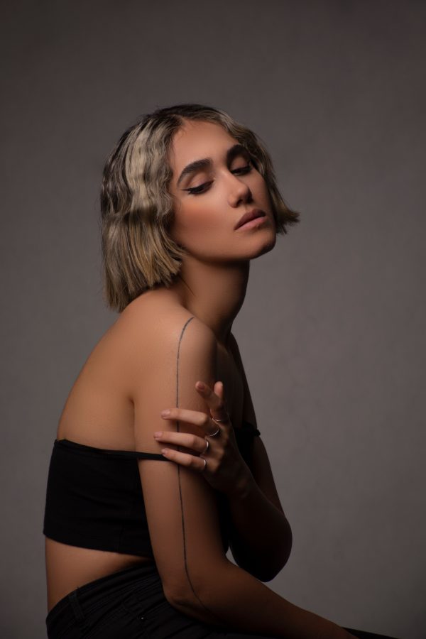 Elegant studio portrait of a stylish woman with a chic hairstyle and minimalist fashion. Mobile 4K