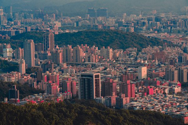 Expansive aerial shot of a bustling cityscape at sunset, showcasing skyscrapers and urban density. Architecture 4K