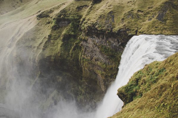 Experience the breathtaking beauty of a powerful waterfall cascading down lush cliffs in Iceland. Nature 4K