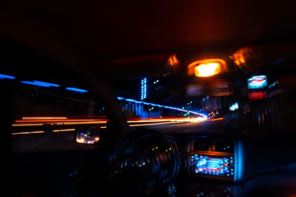 Explore the vibrant light trails of a city night drive captured from inside a moving vehicle. Voitures 4K