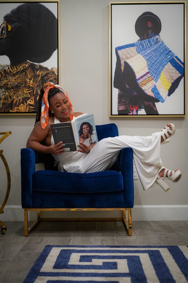 Fashionable woman enjoying a book in a chic, art-filled living space. Mobile 4K