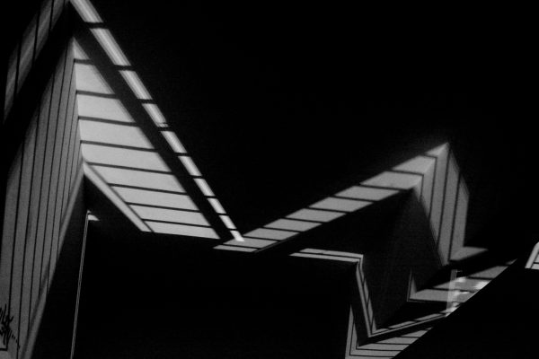 Geometric shadows creating abstract architectural patterns in a monochrome setting. Dark 4K