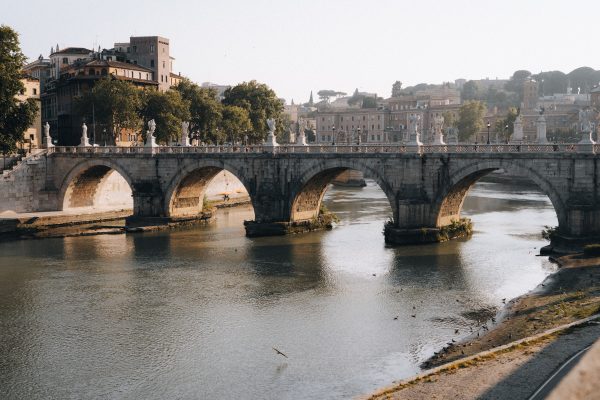 Historic Ponte Sant'Angelo bridge arches over the Tiber River in sunny Rome, Italy. Architecture 4K