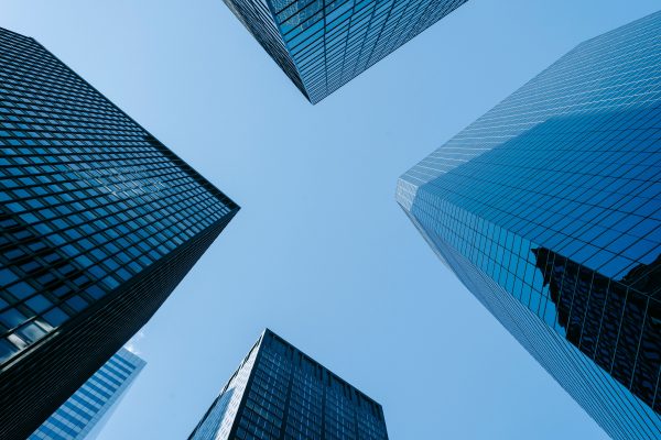 Low angle of high business towers with glass mirrored windows located in megalopolis downtown against blue sky Architecture 4K