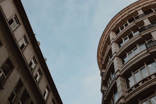 Low angle view of modern city architecture against blue sky, highlighting geometric design. Architecture 4K