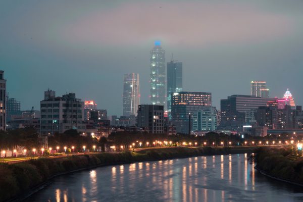 Majestic city skyline along the river, glowing with vibrant lights during nighttime. Architecture 4K