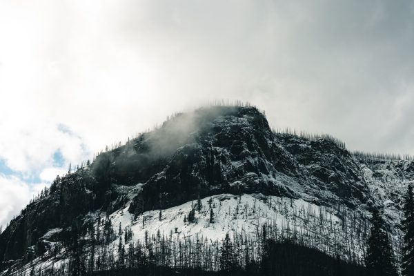 Majestic snow-covered mountain in Kootenay Bay with misty clouds. Nature 4K