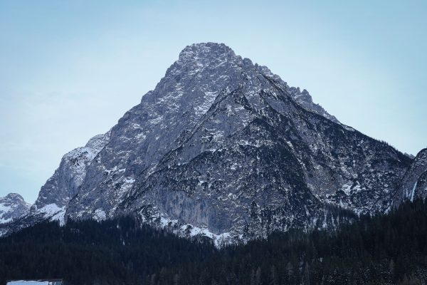 Majestic view of a snow-covered mountain peak with a clear blue sky backdrop. Nature 4K