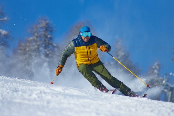 Man skiing downhill with speed on a snowy slope, wearing winter gear and goggles. IA Générative 4K