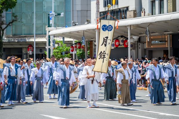 Men wearing traditional attire parade with banners in a Japanese summer festival. Anime 4K