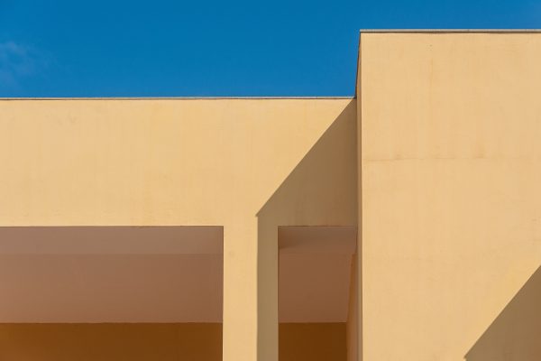 Minimalist architecture with geometric shadows and clear blue sky creates a striking abstract composition. Minimaliste 4K