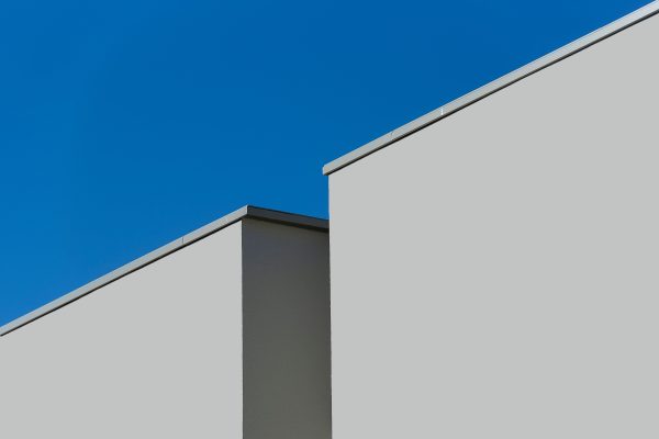 Minimalist modern architecture showcasing geometric lines against a clear blue sky. Minimaliste 4K