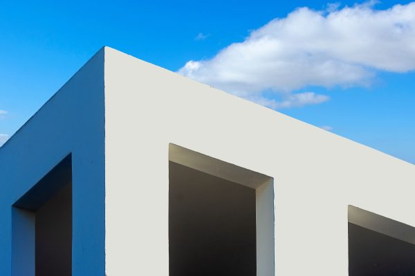 Modern minimalist architecture with white facade and clear blue sky background. Minimaliste 4K