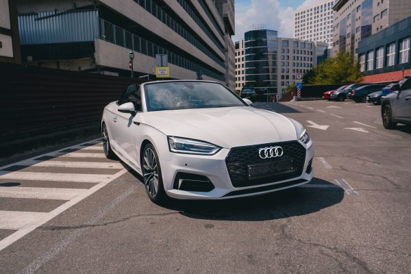 Modern white luxury car parked on a street in Kyiv, Ukraine during a sunny day. Voitures 4K