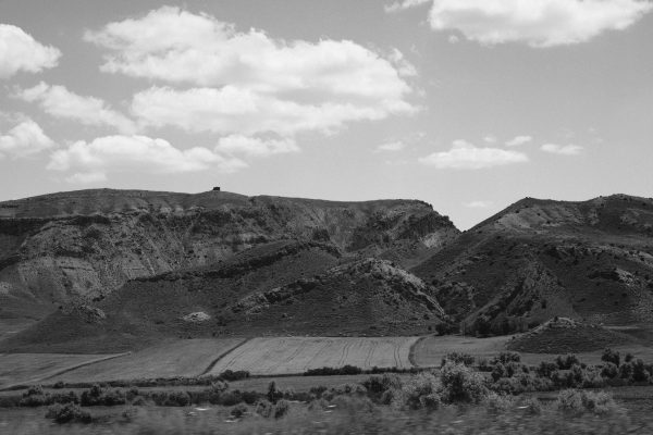 Monochrome aerial view of hilly rural terrain with dramatic sky. Nature 4K