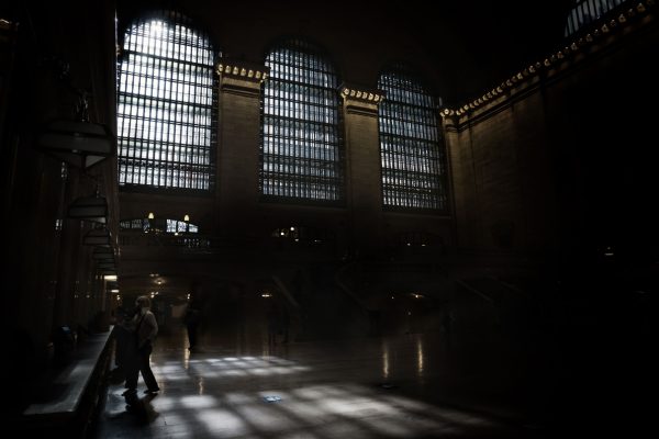Moody interior of Grand Central Terminal with sunlit windows casting shadows on the floor. Dark 4K