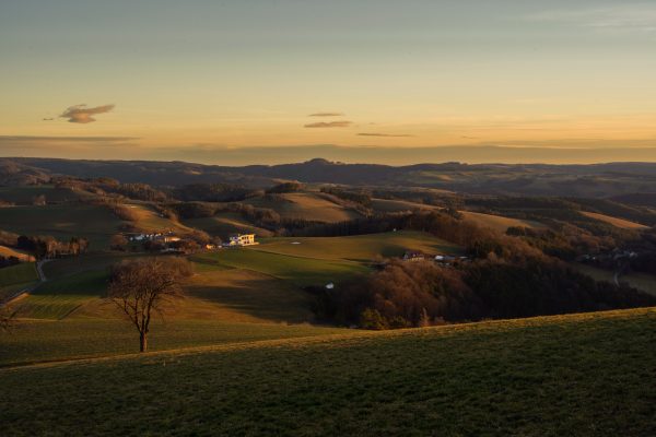 Peaceful countryside hills with houses and trees during a beautiful sunset. Nature 4K