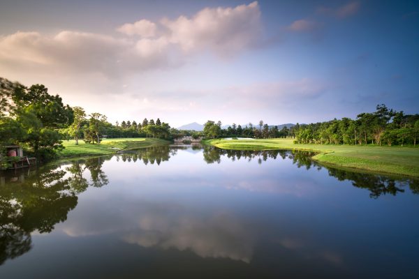Peaceful golf course landscape with a reflective lake and serene surroundings. Nature 4K