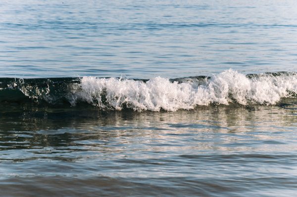 Peaceful ocean wave breaking on the shore under a clear sky in Ireland. Nature 4K