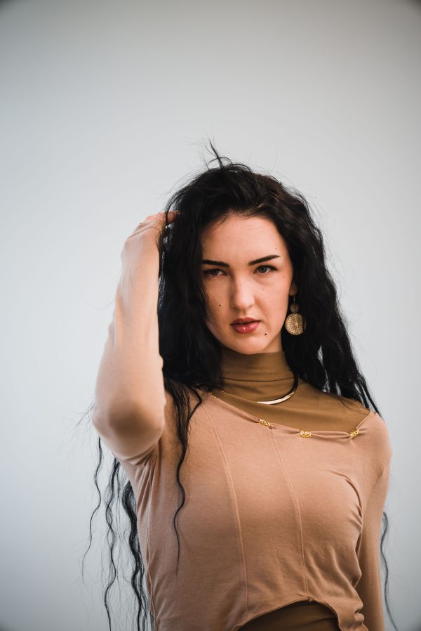 Portrait of a fashionable woman with long hair and modern attire. Mobile 4K