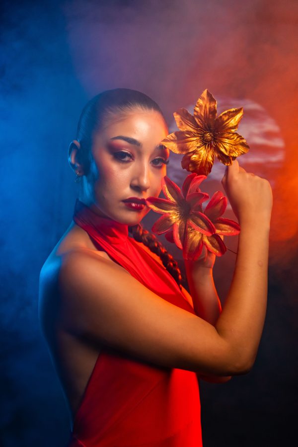 Portrait of a glamorous woman in a red dress with golden flowers, captured in a vibrant studio setting. Mobile 4K