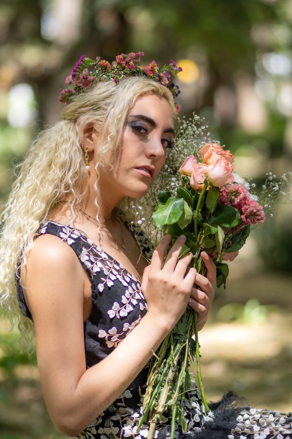 Portrait of a woman with artistic makeup holding flowers outdoors in a Mexico City park. Mobile 4K