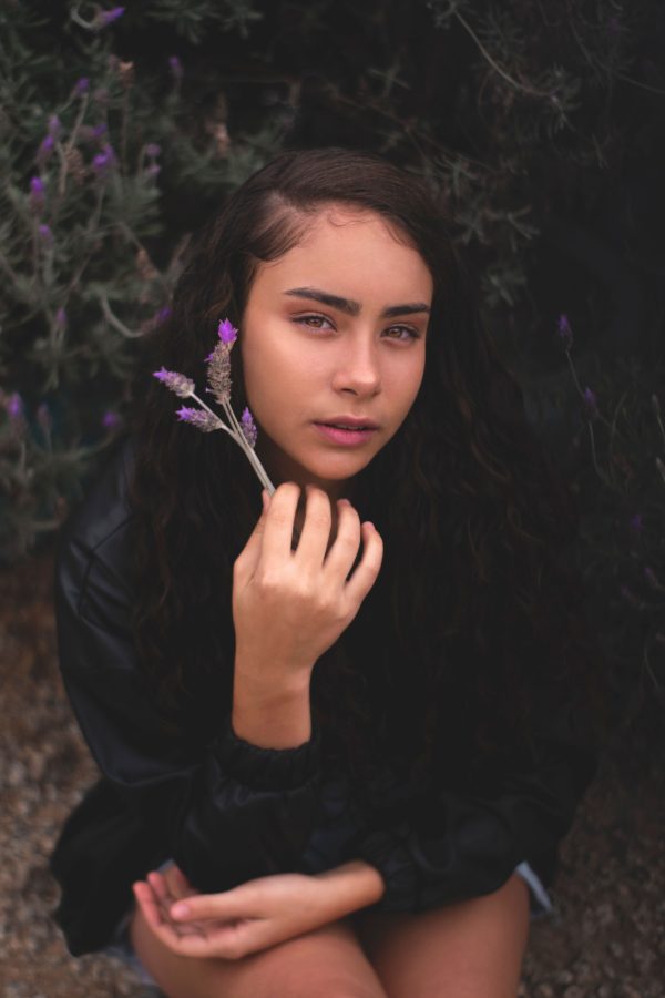 Portrait of a young woman holding lavender in an outdoor natural setting. Mobile 4K