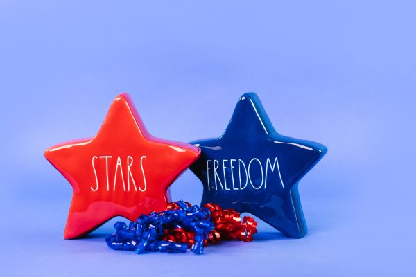 Red and blue star-shaped figurines with text 'STARS' and 'FREEDOM' on a blue background. Espace 4K