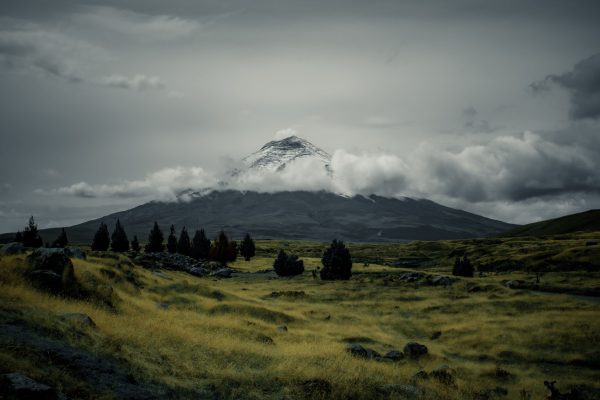Scenic view of a snowcapped volcano amidst a cloudy sky and expansive field. Nature 4K