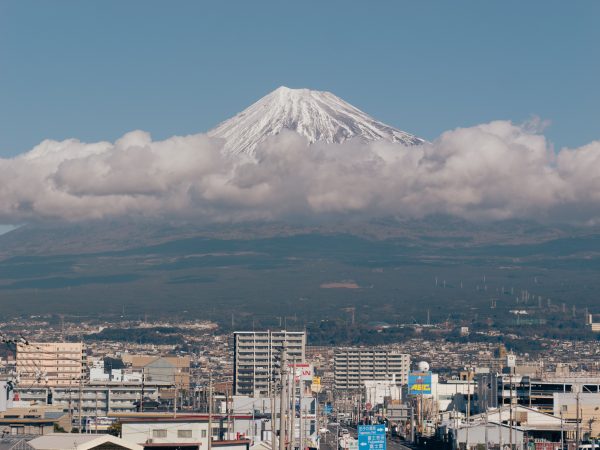 Scenic view of Mount Fuji surrounded by clouds with a cityscape in Shizuoka, Japan. Anime 4K