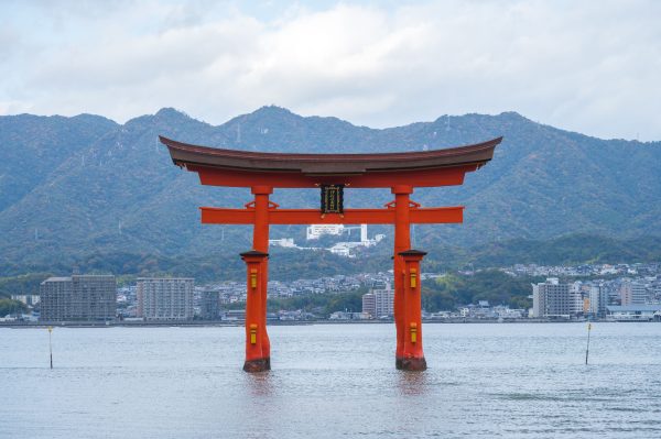 Scenic view of the floating Torii gate at Itsukushima Shrine in Japan, with mountains and sea. Anime 4K
