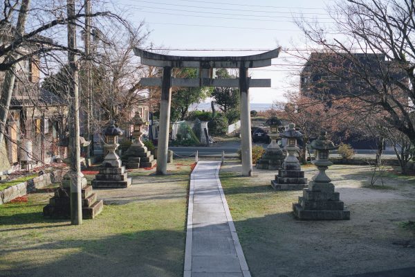Serene Japanese garden in Shiga with a traditional torii gate and stone lanterns under sunlight. Anime 4K