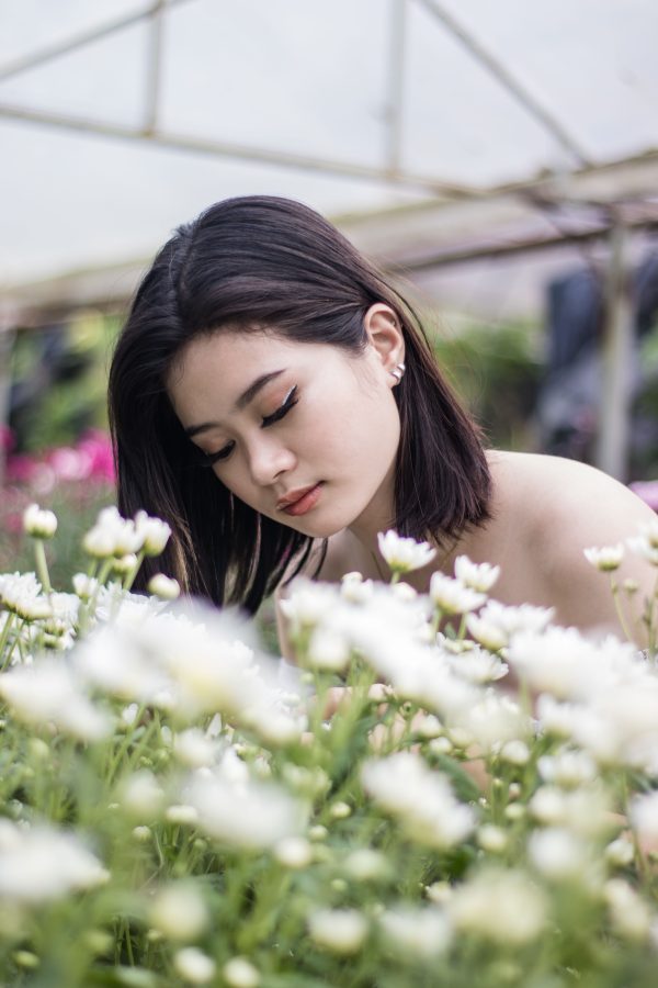 Serene portrait of a woman in a lush flower garden, showcasing natural beauty. Mobile 4K