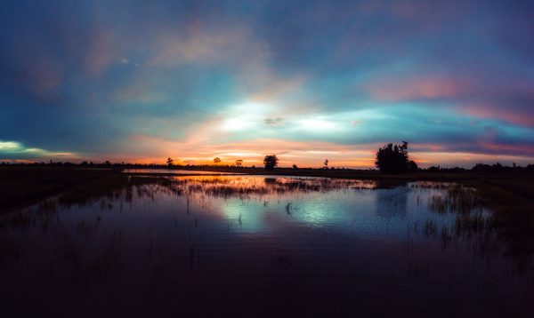 Serene sunset over a calm river with colorful sky reflection, evoking peace and tranquility. Nature 4K