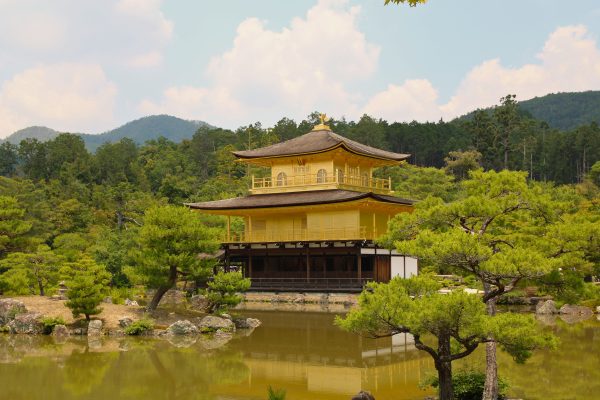 Serene view of Kinkaku-ji Temple reflecting in a pond surrounded by nature in Kyoto, Japan. Anime 4K