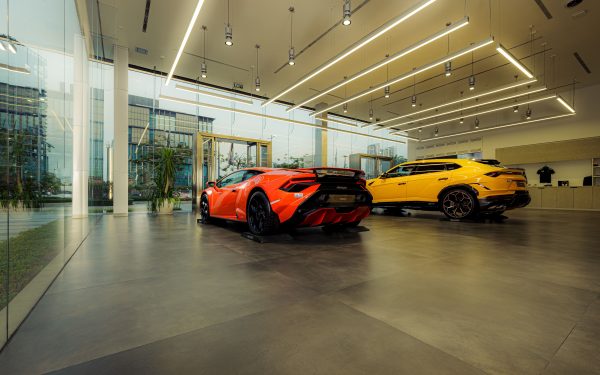 Showroom featuring luxury sports cars, Lamborghini models, with sleek design and modern architecture. Voitures 4K