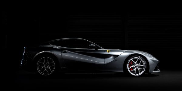 Side profile of a luxury sports car against a dark background, showcasing sleek design. Voitures 4K