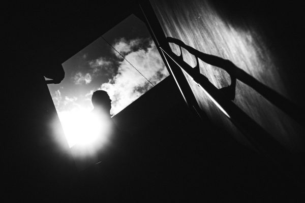 Silhouette of a person against the sun with dramatic shadows in black and white. Dark 4K